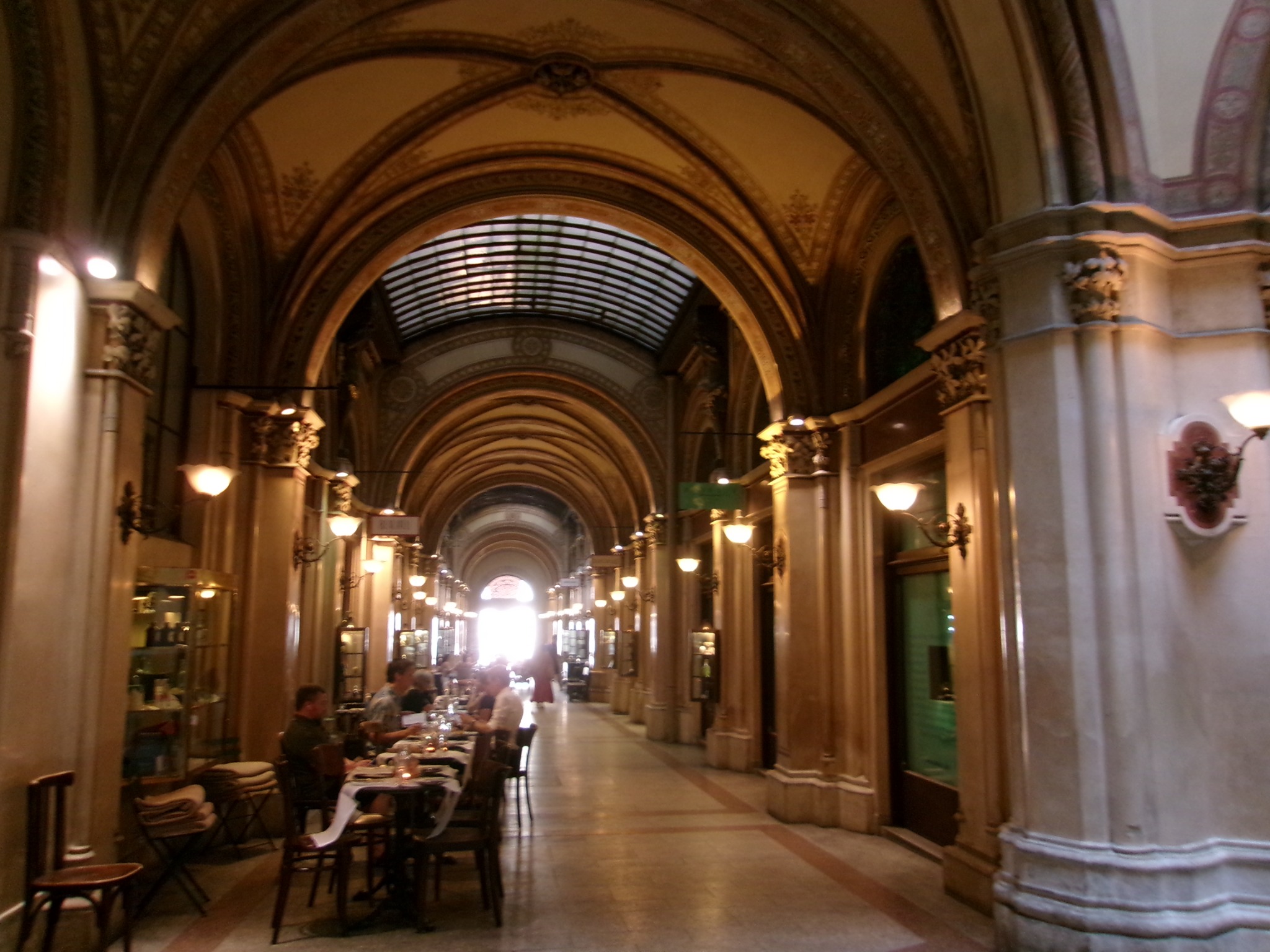 An ornate vaulted interior with warm lights and seating