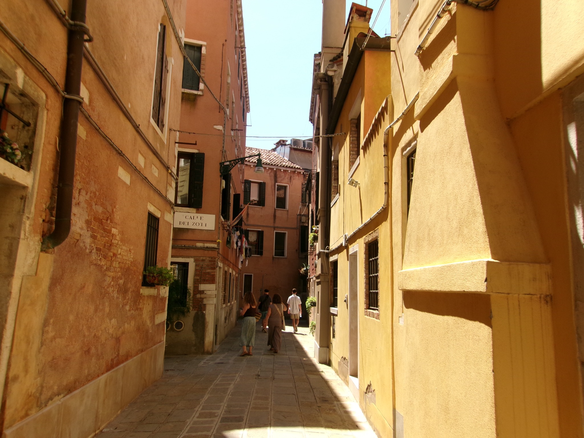 Sunlit passage between ochre buildings