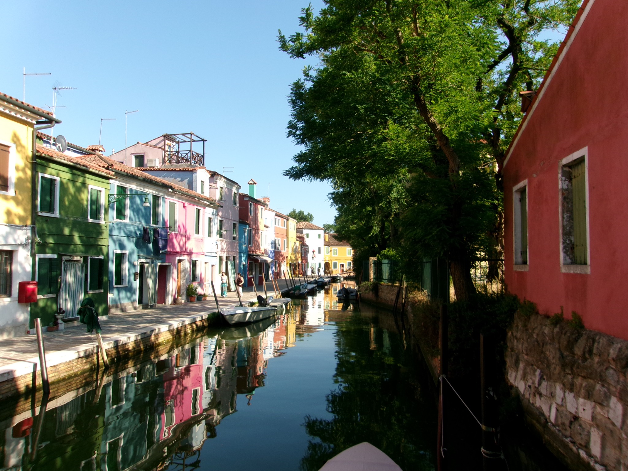 Colorful houses and trees reflected in a quiet canal