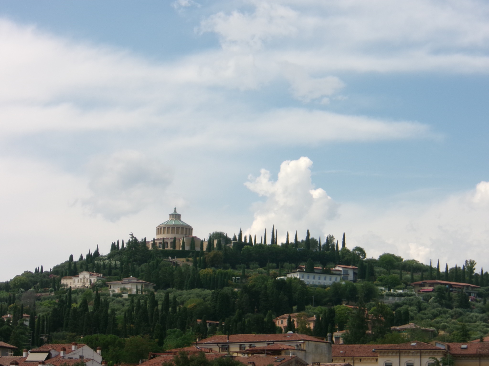 A domed building on a green hill beneath a cloudy sky