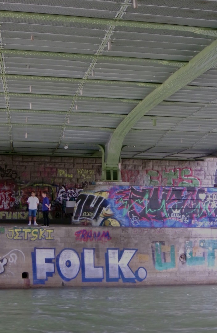 Graffiti-covered walls beneath a large roof structure