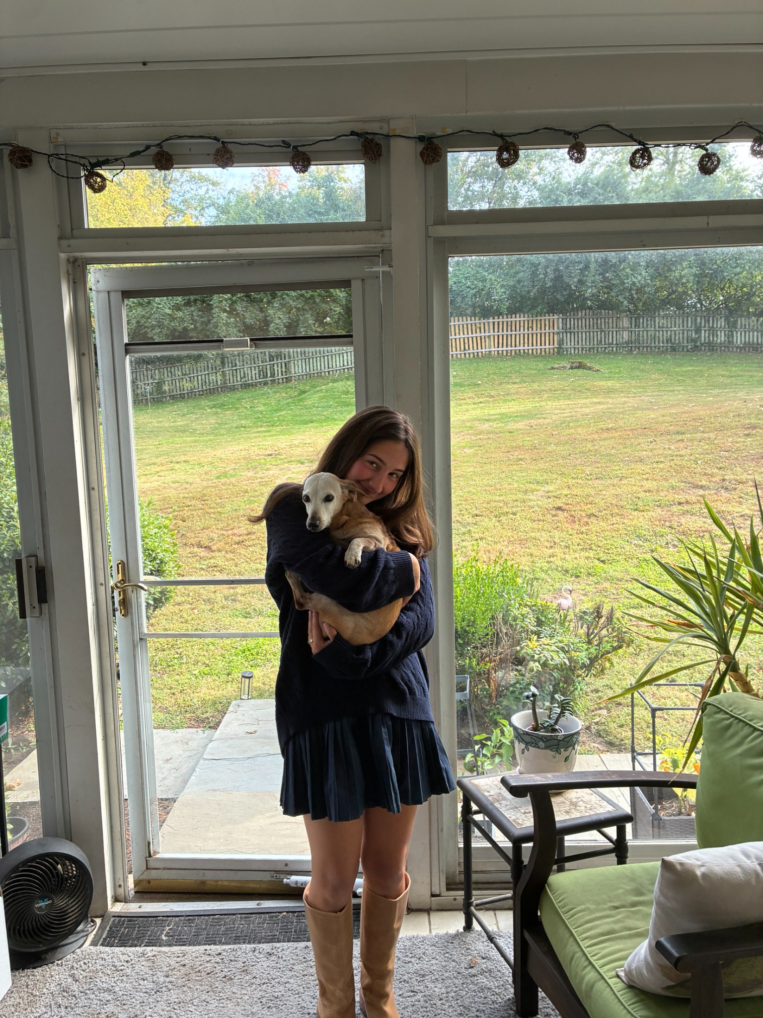 Rea Sofia Bifano holding a dog in a sunlit room